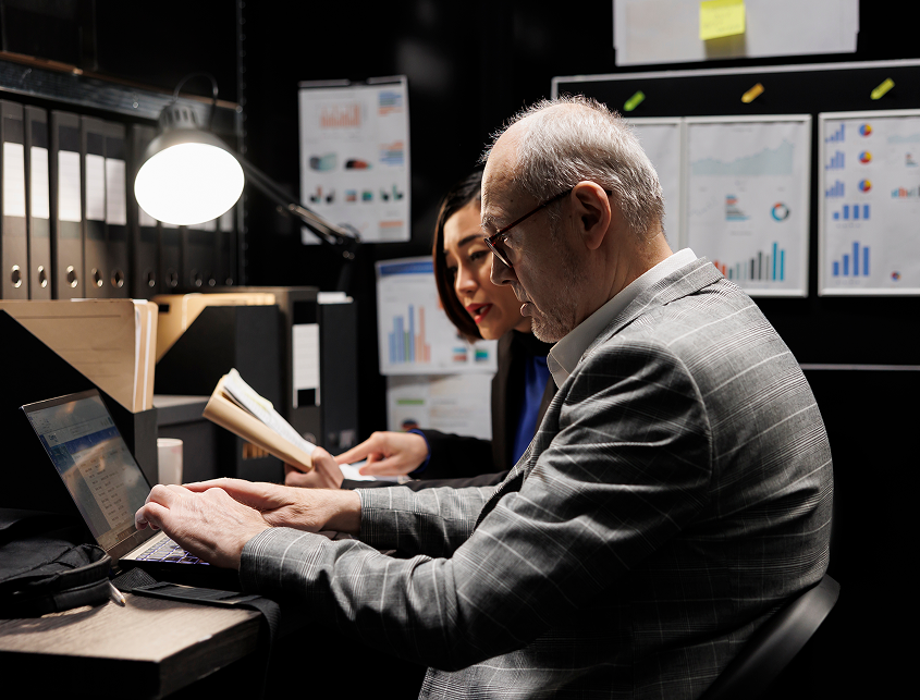 woman training an older man in security matters with a laptop