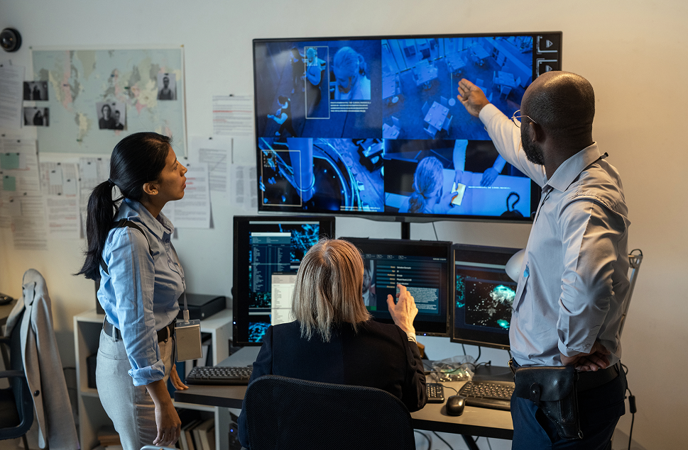 security professional training two ladies in front of a computer displaying camera feeds